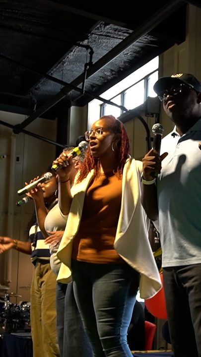 Singers leading worship with microphones raised