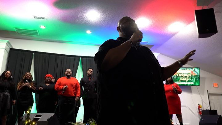 Worship leader under colored stage lights