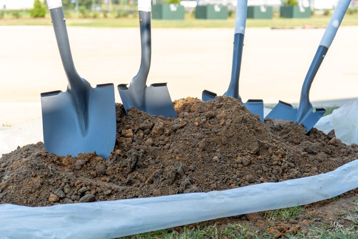 Ceremonial shovels resting in fresh soil