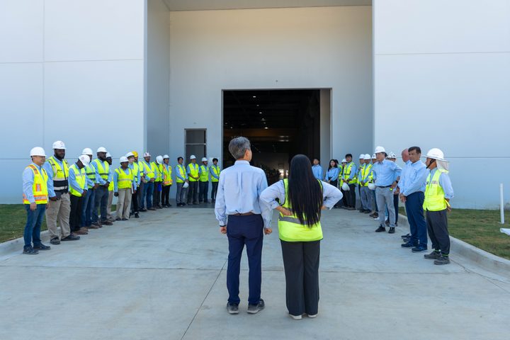 Staff in safety vests lined up to welcome the visit