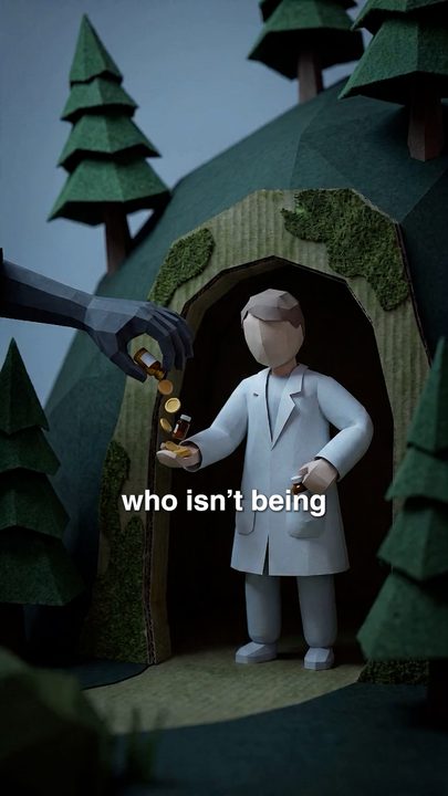 A paper doctor standing at the mouth of a cave in a paper-craft hillside