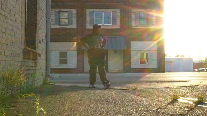 Teresa walking down a sunlit small-town street